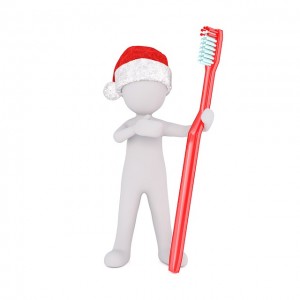 White toy figure wearing a santa hat and holding a toothbrush